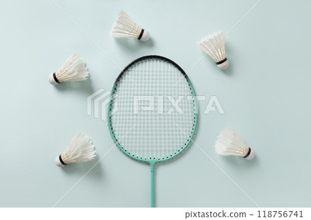 White feather badminton shuttlecocks and two badminton rackets on light blue background. View from above. Concept racket sport. Leisure games. White feather badminton shuttlecocks and two badminton rackets on light blue background. View from above. Concept racket sport. Leisure games. 118756741