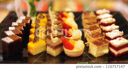 Beautiful multicolored decorated baked sweet tasty party cakes or catering cakes for party, bar dessert selection with cake, pie and pastries catering banquet, coffee break buffet at a conference 118757147