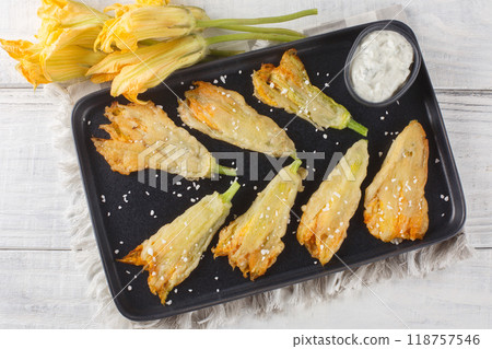 Greek traditional stuffed zucchini flowers closeup on the plate. Horizontal top view Greek traditional stuffed zucchini flowers closeup on the plate. Horizontal top view 118757546