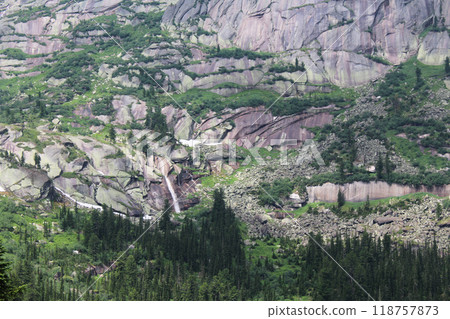 Small waterfall in natural park. High green steep slopes with green trees, rocks 118757873