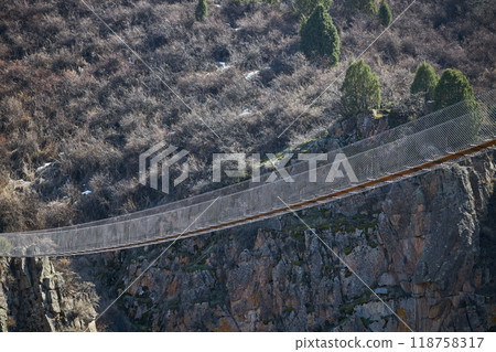 Excursion suspension bridge over the gorge. Sightseeing holiday tour in Kyrgyzstan. Crossing between two mountains 118758317