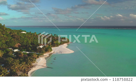 Stunning tropical island with turquoise waters, white sand beaches, lush palm trees, and a blue sky captured from a drone. Perfect for a dream vacation in french polynesia 118758822