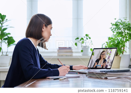 Young female college student studying using laptop computer for video chat 118759141