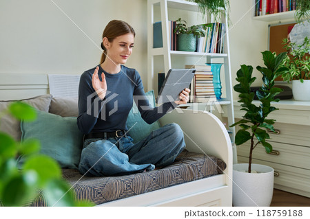 Teenage female student at home looking talking in web camera of digital tablet 118759188