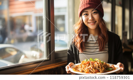 一個微笑的女人拿著一盤義大利麵 118759301