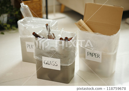 Organizing Glass And Paper Waste in Separate Recycling Bins 118759678