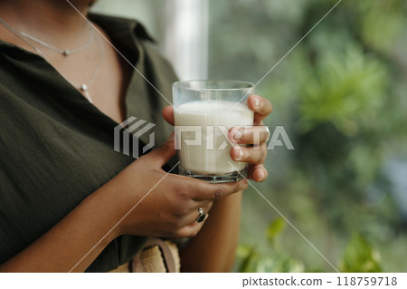 Holding Glass of Milk with Green Background 118759718