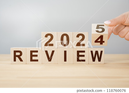 Review 2025. hand flips wooden cube and changes words REVIEW 2024 to REVIEW 2025. Business 2025 review new year concept. Economy and business. Phrase 2025 review on wooden table 118760076