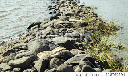Rocky bank of a large river on a sunny day Rocky bank of a large river on a sunny day 118760594