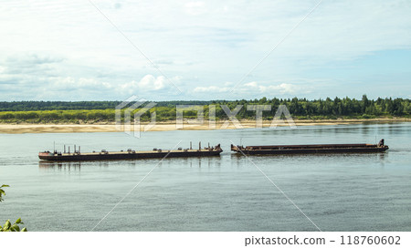 A large river vessel pulls two barges loaded with timber down the river 118760602