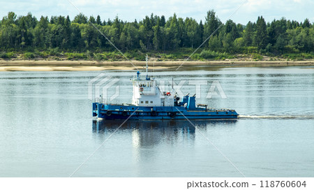 A large river vessel pulls two barges loaded with timber down the river A large river vessel pulls two barges loaded with timber down the river 118760604