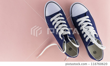 blue sports shoes with laces on a pink background, insulating blue sports shoes with laces on a pink background, insulating 118760620