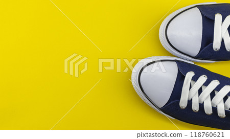casual sports shoes in blue on a yellow background casual sports shoes in blue on a yellow background 118760621