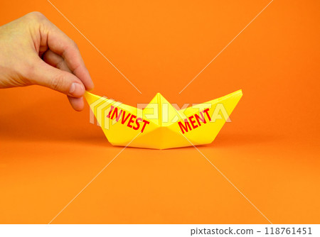 Investment symbol. Concept word Investment on beautiful yellow paper boat. Beautiful orange background. Businessman hand. Business investment concept. Copy space. 118761451