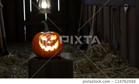 Halloween jack-o'-lantern lit up in an eerie barn scene 118762088
