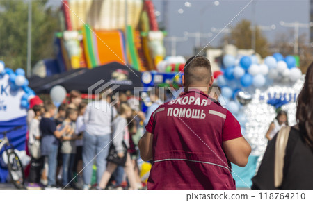 Ambulance worker on a street where there are a lot of people 118764210