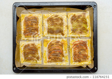 Freshly prepared apple pastries on a baking tray ready for the oven. 118764231