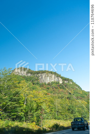 A winding road with view of mountains in White Mountain National Forest. A winding road with view of mountains in White Mountain National Forest. 118764696