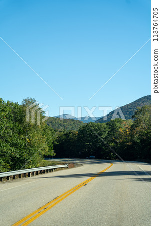 A winding road with view of mountains in White Mountain National Forest. A winding road with view of mountains in White Mountain National Forest. 118764705