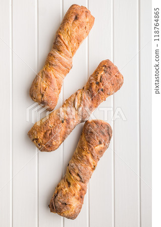 Crusty rustic baguette on white table. Top view. 118764865