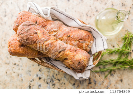 Crusty rustic baguette in basket on kitchen table. Top view. Crusty rustic baguette in basket on kitchen table. Top view. 118764869