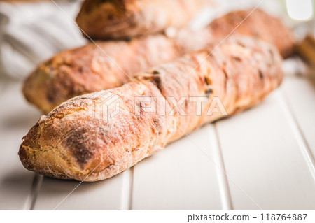 Crusty rustic baguette on white table. 118764887