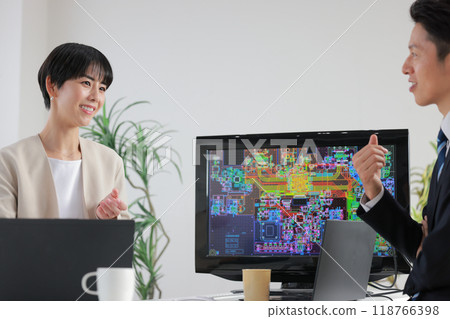 Male and female engineers discussing while looking at CAD drawings_2 118766398