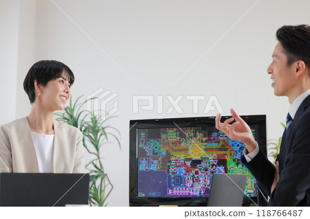 Male and female engineers discussing while looking at blueprints_1 118766487