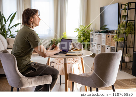 Young stylish man working on a laptop at home. Freelance concept, remote work. Young stylish man working on a laptop at home. Freelance concept, remote work. 118766880