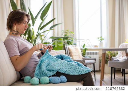 Hipster feminine male crochet handmade knitting hobby with colored yarn and hook at white interior Hipster feminine male crochet handmade knitting hobby with colored yarn and hook at white interior 118766882