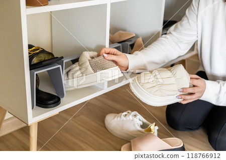 Smiling woman choosing footwear shoes closet comfortable storage contemporary organize at home Smiling woman choosing footwear shoes closet comfortable storage contemporary organize at home 118766912