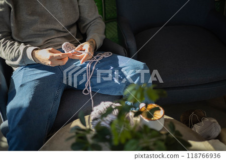 Hipster feminine male crochet handmade knitting hobby with colored yarn and hook at wooden interior Hipster feminine male crochet handmade knitting hobby with colored yarn and hook at wooden interior 118766936