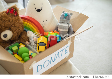 On the living room couch is a box full of toys for donation. Teddy bear soft toy On the living room couch is a box full of toys for donation. Teddy bear soft toy 118766958