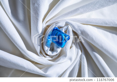 Washing gel capsule pods with laundry detergent on a pile of white cloth background Washing gel capsule pods with laundry detergent on a pile of white cloth background 118767006