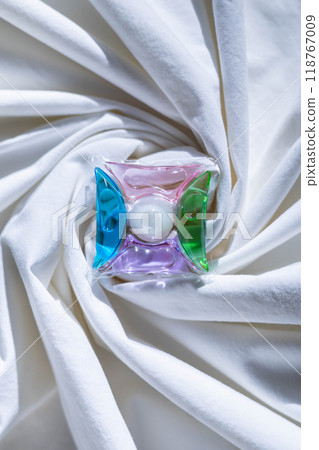 Washing gel capsule pods with laundry detergent on a pile of white cloth background 118767009