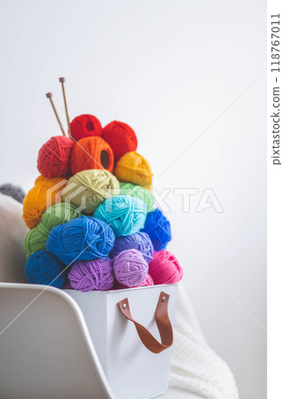 Lots of bright, colorful yarns for knitting and crochet in a stylish scandi style basket.  118767011