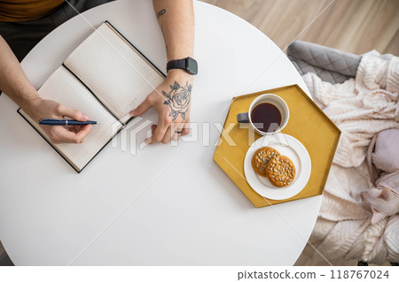 Top view of a businessman writing on a blank notepad. High angle view of a man handwriting a letter 118767024