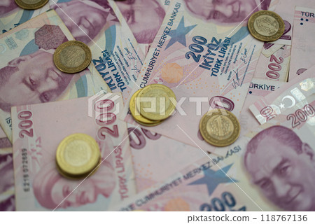Scattered Turkish lira banknotes and coins on a table. Representation of Turkey's national currency and economic context. Suitable for finance, banking, and trade topics  118767136