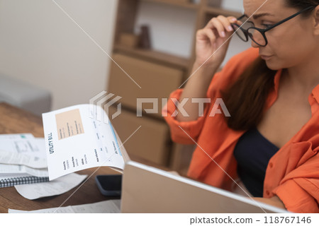woman, at home, distressed by a utility bill, contemplates mortgage payment challenges and escalating debt. woman, at home, distressed by a utility bill, contemplates mortgage payment challenges and escalating debt. 118767146