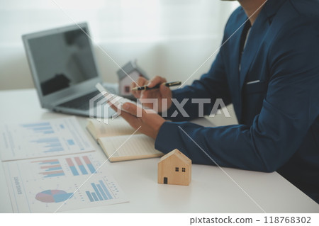 Businessmen holding pens, signing home titles with insurance, care about real estate services and the idea of real estate agents offering interest in installments to their customers. 118768302