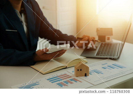 Businessmen holding pens, signing home titles with insurance, care about real estate services and the idea of real estate agents offering interest in installments to their customers. 118768308