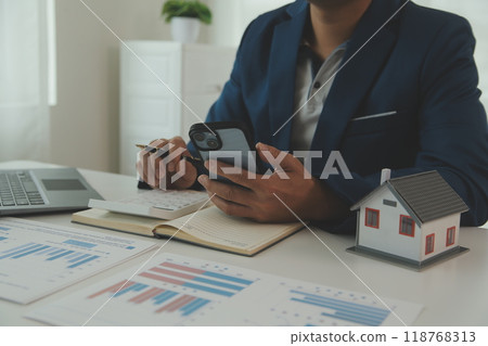 Businessmen holding pens, signing home titles with insurance, care about real estate services and the idea of real estate agents offering interest in installments to their customers. Businessmen holding pens, signing home titles with insurance, care about real estate services and the idea of real estate agents offering interest in installments to their customers. 118768313
