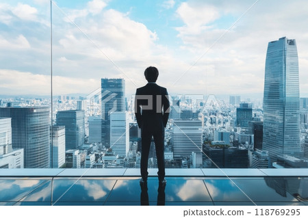 The back view of a male office worker looking down at the Tokyo skyline from a high-rise (job change, employment, new graduates, foreign-affiliated companies) 118769295