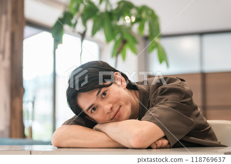 Smiling young Asian/Japanese man relaxing at home/cafe (relaxed) 118769637