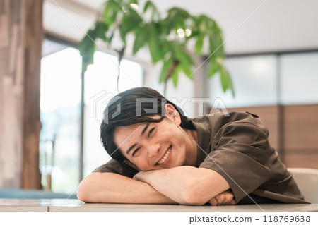 Smiling young Asian/Japanese man relaxing at home/cafe (relaxed) 118769638