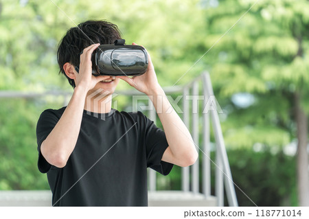 A man wearing VR goggles and experiencing virtual reality Metaverse 118771014