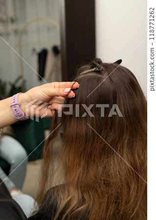 The hairdresser holds the strands of the client's hair in his hands. Barbershop 118771262