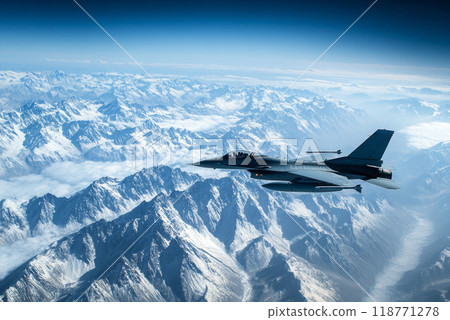 Military jet flying over snow-covered mountain range under clear blue sky 118771278