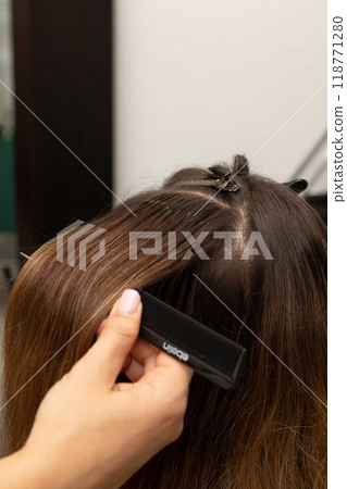 The hairdresser holds the strands of the client's hair in his hands. Barbershop The hairdresser holds the strands of the client's hair in his hands. Barbershop 118771280