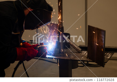 Competitions among welders. A man in a protective mask is welding. 118772028